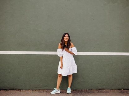 Girl wearing colorful adidas sneakers and a white dress